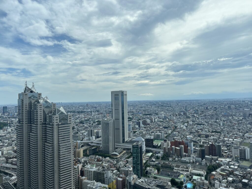 「東京の高層ビル群と広がる街並みを上空から撮影した写真」